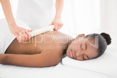 Pretty woman enjoying a bamboo roller massage