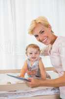 Portrait smiling of blonde with his son using digital tablet