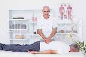 Physiotherapist doing back massage to his patient