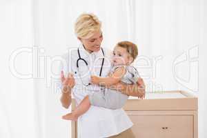 Smiling blonde doctor and child with stethoscope