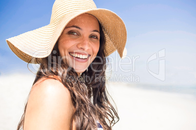 Pretty brunette looking at camera at the beach