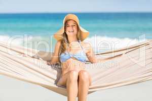 Pretty woman relaxing in the hammock and smiling at camera