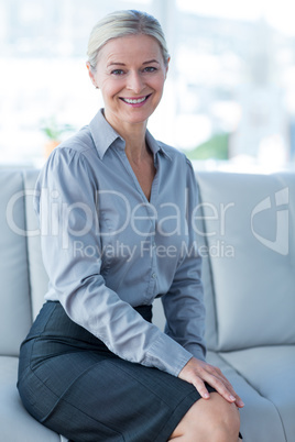 Happy businesswoman sitting on couch