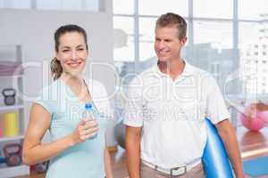 Smiling woman with her trainer looking at camera