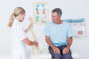 Doctor showing anatomical spine to her patient