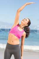 Pretty fit woman doing fitness beside the sea