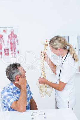 Doctor showing anatomical spine to her patient