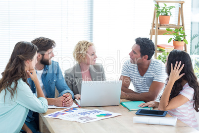 Colleagues using laptop at office