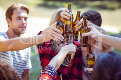 Happy friends drink beer in the park
