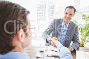 Smiling businessman shaking hands with a co worker