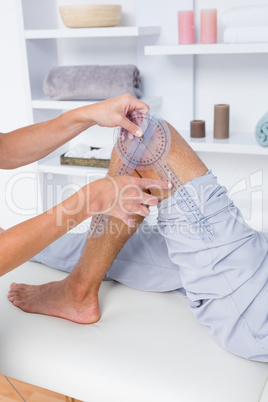 Doctor examining man leg with tool