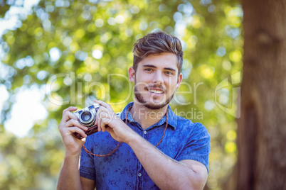 Handsome hipster holding vintage camera