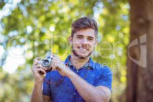 Handsome hipster holding vintage camera