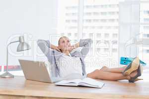 Smiling businesswoman relaxing on her office