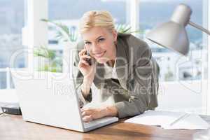 Smiling businesswoman on the phone looking at camera
