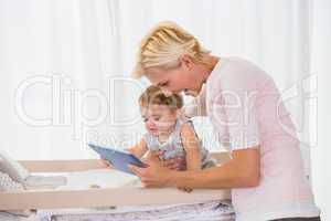 Smiling blonde woman with his son using digital tablet