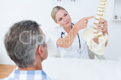 Doctor explaining anatomical spine to her patient