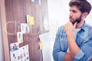 Puzzled businessman looking post its on the wall