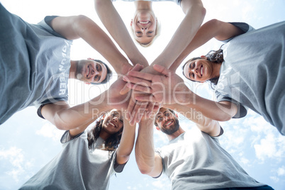 Happy volunteers putting their hands together