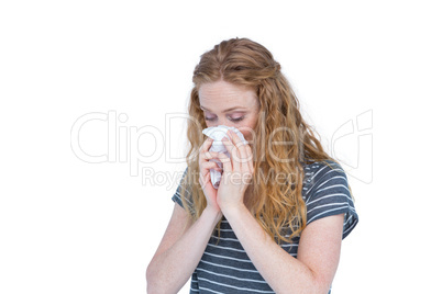 Sick blonde woman blowing her nose