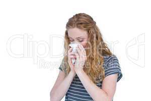 Sick blonde woman blowing her nose