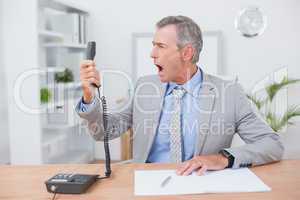 Irritated businessman answering phone