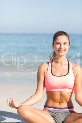 Fit woman doing yoga beside the sea