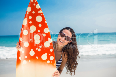 Pretty brunette with a surfboard looking at camera