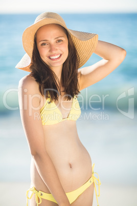 Brunette relaxing with a straw hat smiling at camera