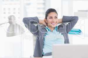 Smiling businesswoman relaxing on her office