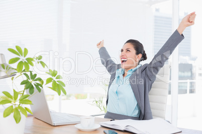 Happy businesswoman with raised arms