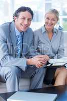 Smiling businessman and secretary looking at diary