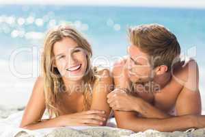 Happy couple relaxing together in the sand