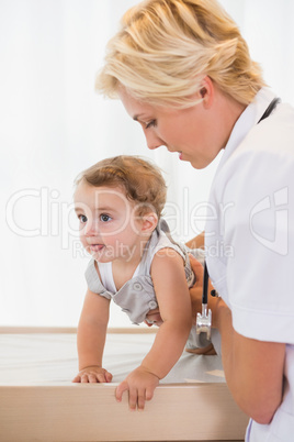 Blonde doctor with a child and stethoscope
