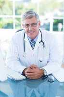 Smiling doctor sitting at his desk