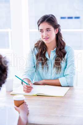Concentrated woman taking notes during a meeting