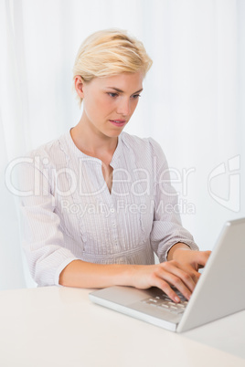 Happy blonde woman using laptop