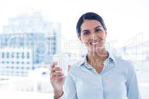 Smiling businesswoman holding disposable cup