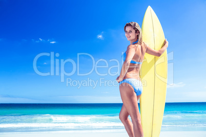 Pretty blonde woman holding surf board