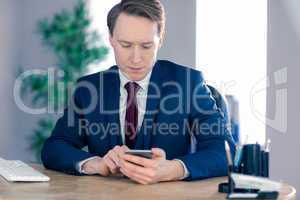 Serious businessman using his smartphone