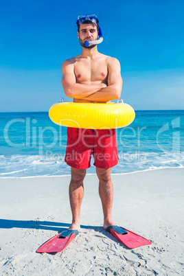Man wearing flippers and rubber ring at the beach