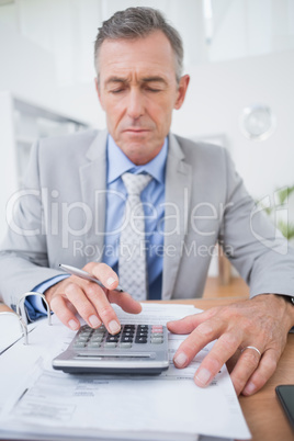 Businessman using calculator to calculate finance