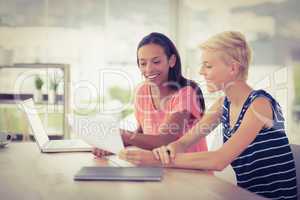 Two smiling businesswomen working together
