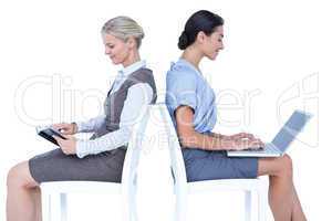 Businesswomen using laptop and reading book