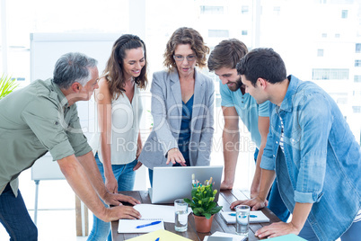 Casual colleagues using laptop in the office