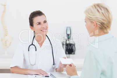 Patient giving cheque to her doctor