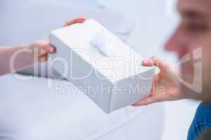 Businesswoman giving paper tissue to her colleague
