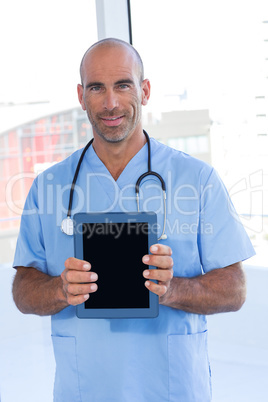 Smiling doctor holding tablet computer