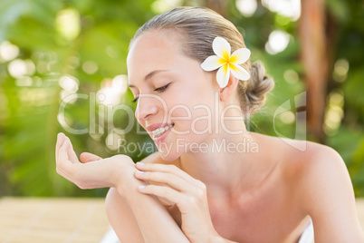 Peaceful blonde lying on towel and looking her hand