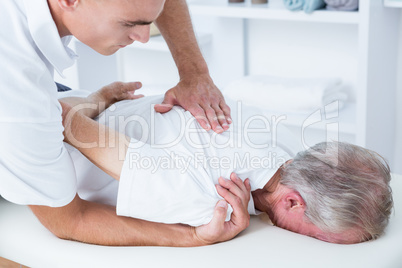 Physiotherapist doing shoulder massage to his patient